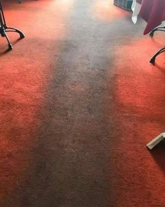 A red function room carpet with a grey dirty lane down the middle, the wand at the edge