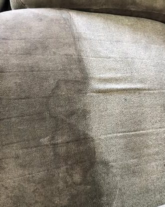A sofa seat with one half cleaned and the other still marked