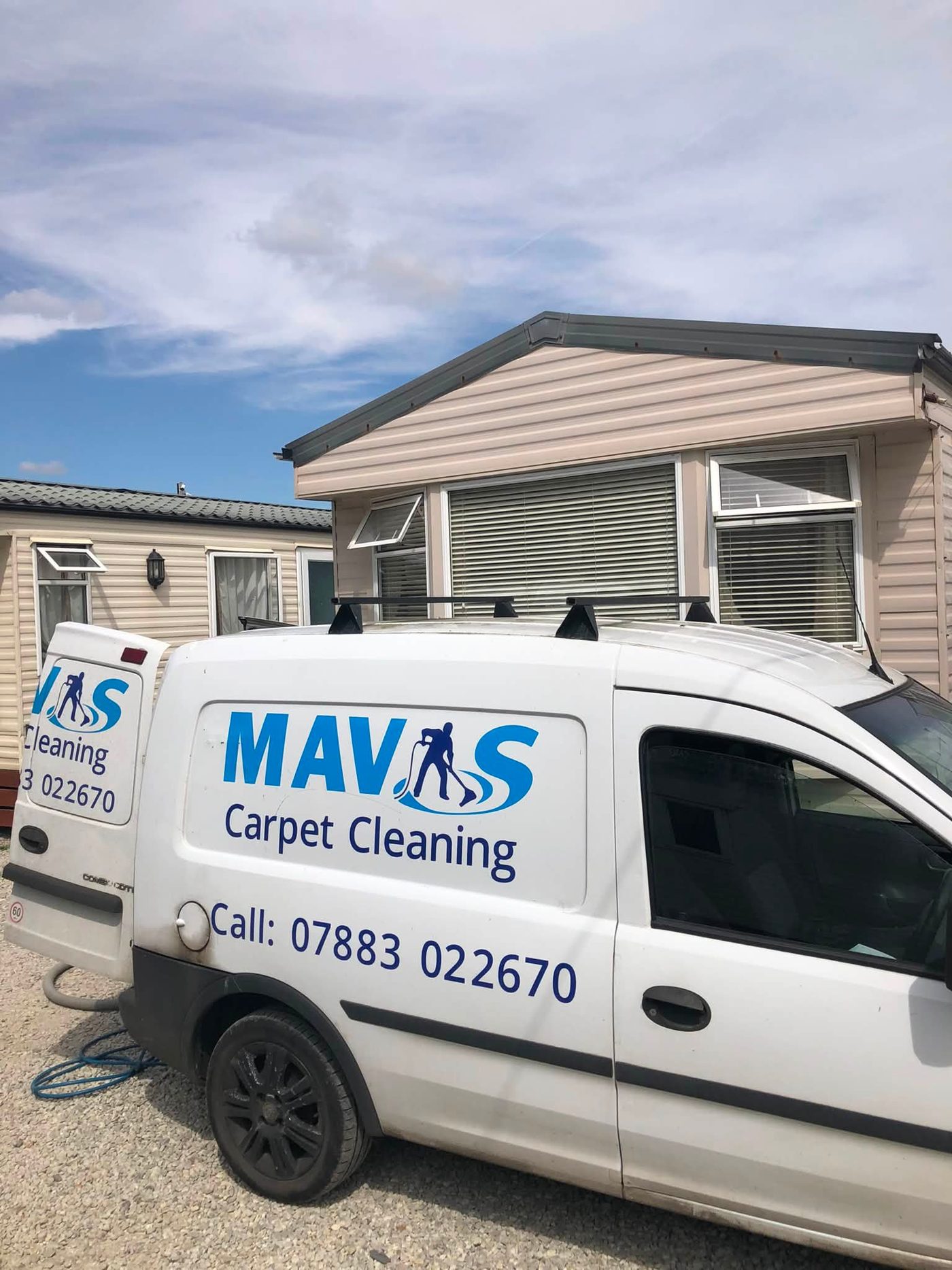 The Mavis Carpet Cleaning van parked beside a static caravan